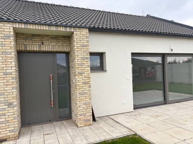 Na predaj dizajnový 4-izbový rodinný dom v Tomášove - Rodinný dom na Fialkovej v Tomášove s tehlovým obkladom a priestrannými sklenenými dverami.