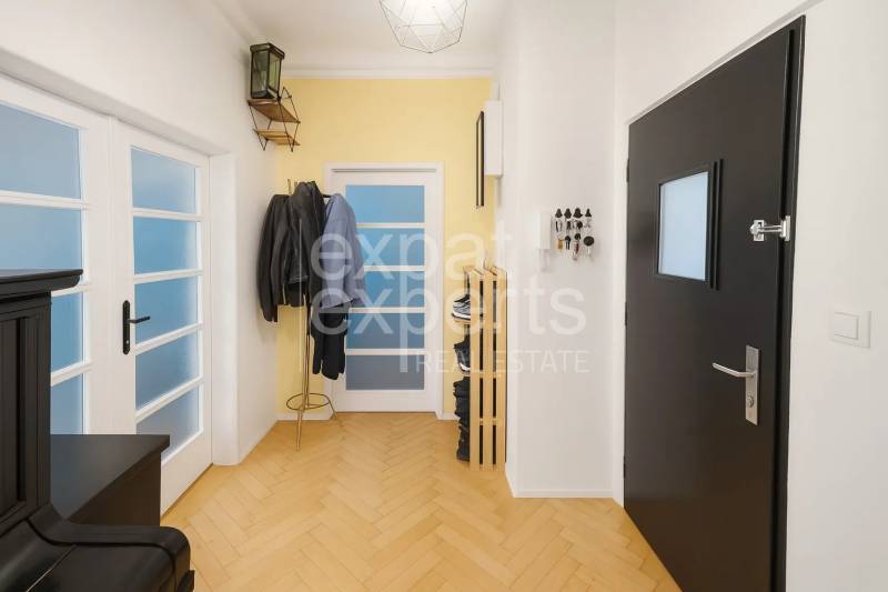 Svetlý, jedinečný 2i byt 62m2, po rekonštrukcií, s pivnicou   - Chodba v 3-izbovom byte s podlahou s dreveným dekorom, vešiakom a dverami.