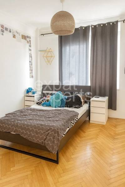 Svetlý, jedinečný 2i byt 62m2, po rekonštrukcií, s pivnicou   - Spálňa s posteľou, nočnými stolíkmi a podlahou s dreveným dekorom v 3-izbovom byte.