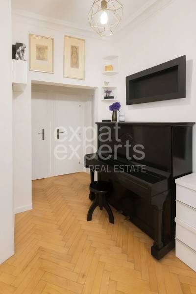 Svetlý, jedinečný 2i byt 62m2, po rekonštrukcií, s pivnicou   - Interiér 3-izbového bytu so starožitným čiernym klavírom a podlahou s dreveným dekorom.