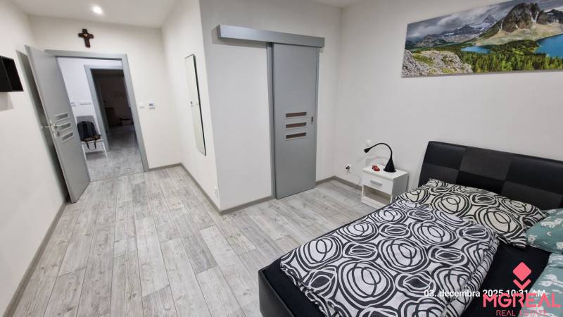 Nový rodinný dom, 7 minút od centra Košíc v tichej uličke pod lesom - Spálňa v rodinnom dome s podlahou s dreveným dekorom a posuvnými dverami.