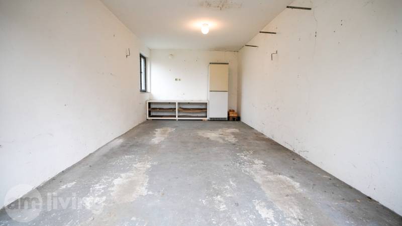 RODINNÝ DOM s garážou na PREDAJ - Dubnica nad Váhom - až 758m²  - Garáž v rodinnom dome s betónovou podlahou a bielymi stenami.