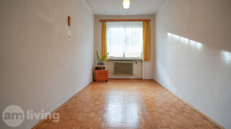 RODINNÝ DOM s garážou na PREDAJ - Dubnica nad Váhom - až 758m²  - Izba v rodinnom dome s podlahou s dreveným dekorom, radiátorom a oknom s záclonou.