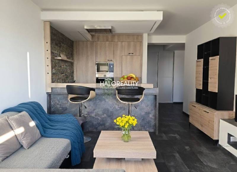 Predaj, dvojizbový byt Trnava, Arbória, garážové stá... - Obývačka v 2-izbovom byte s otvorenou kuchyňou a podlahou s dreveným dekorom.