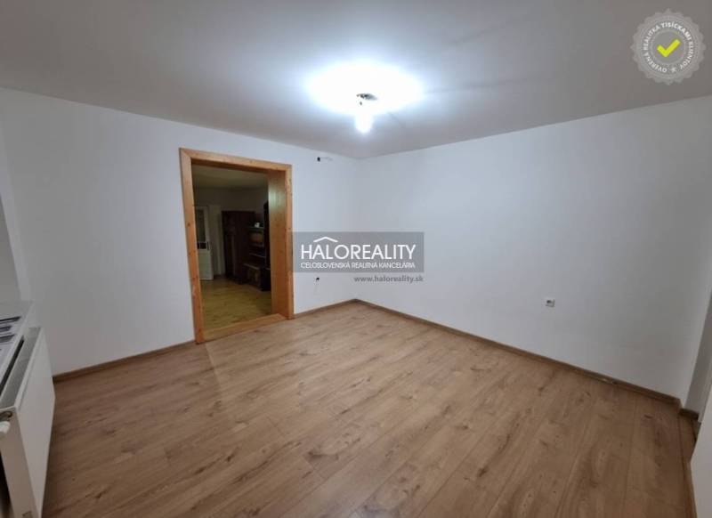 Predaj, rodinný dom Zeleneč - Interiér rodinného domu s podlahou s dreveným dekorom a bielymi stenami.