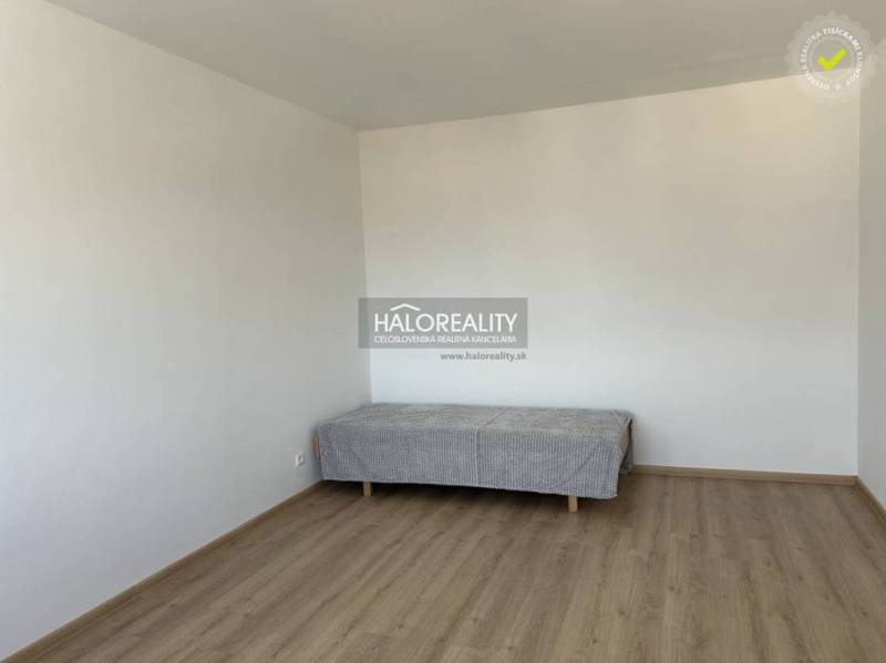 Prenájom, jednoizbový byt Prievidza, Čierne Mesto - ... - Jednoduchá miestnosť v 1-izbovom byte s posteľou a podlahou s dreveným dekorom.