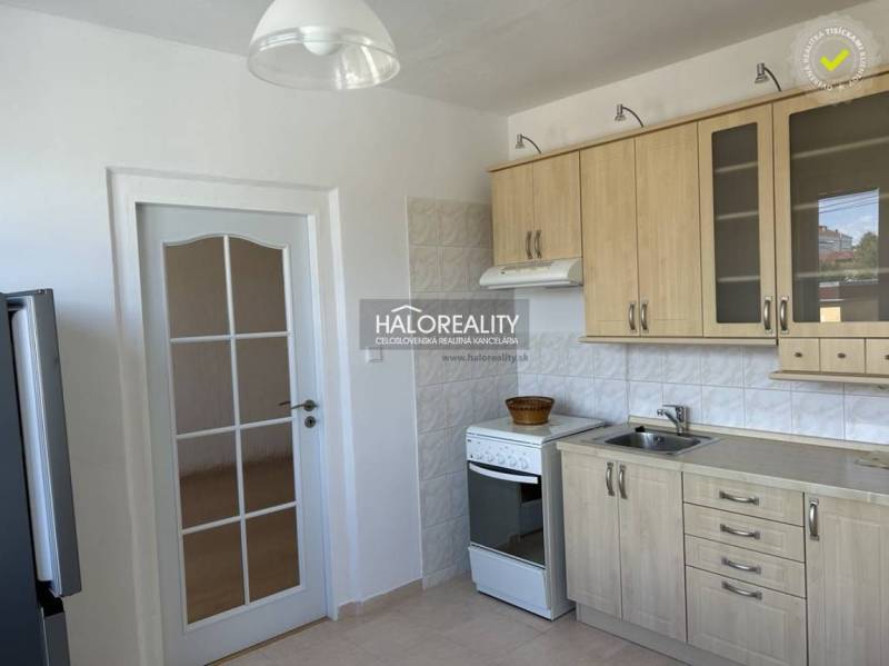 Prenájom, jednoizbový byt Prievidza, Čierne Mesto - ... - Kuchyňa s dreveným dekorom, kachličkovaná stena, biely sporák a biele dvere.