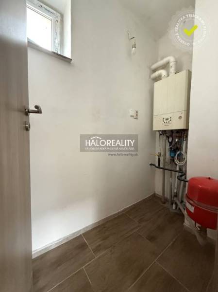 Predaj, rodinný dom Chynorany - Technická miestnosť v rodinnom dome s kotlom a podlahou s dreveným dekorom.