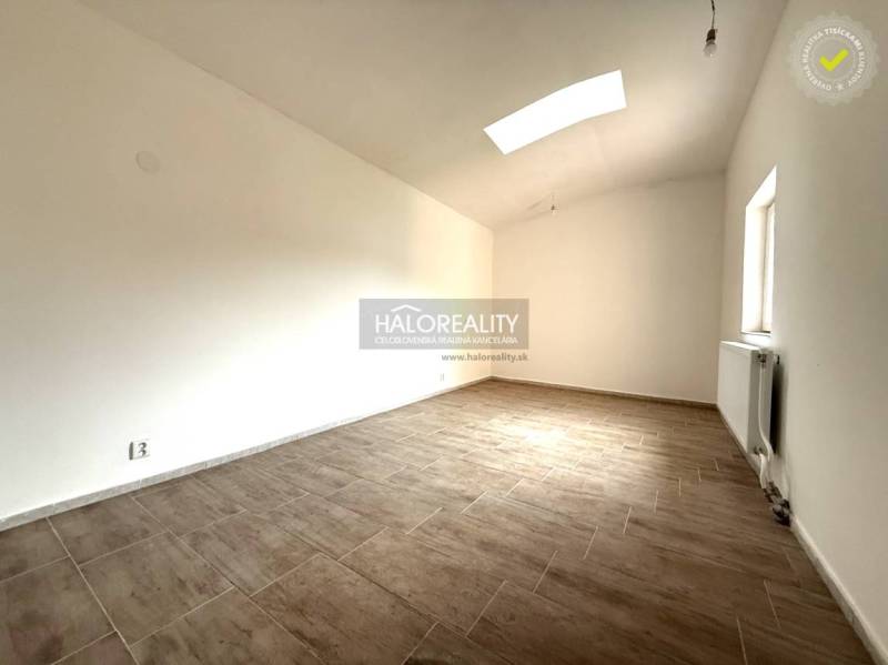 Predaj, rodinný dom Chynorany - Priestranná miestnosť s podlahou s dreveným dekorom v rodinnom dome.