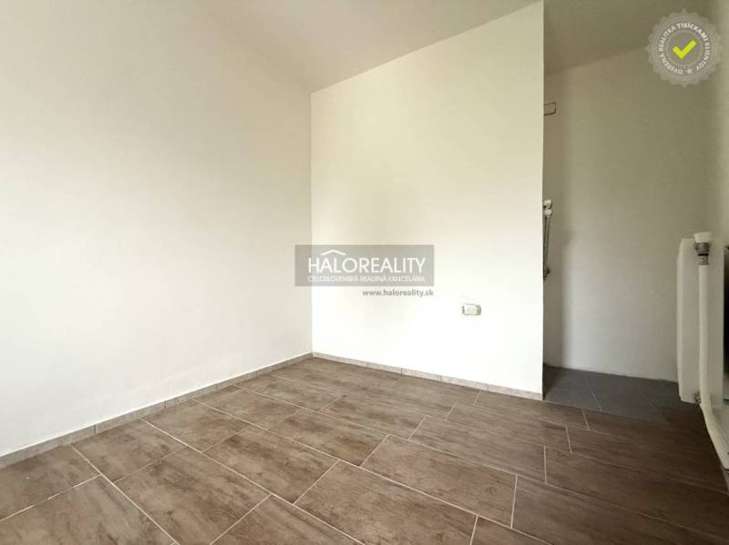 Predaj, rodinný dom Chynorany - Prázdna miestnosť s podlahou s dreveným dekorom v rodinnom dome.