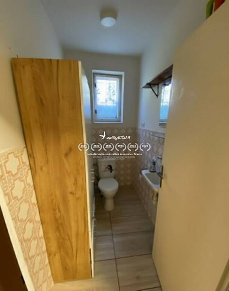 V exkluzívnom zastúpení majiteľa ponúkame na predaj rodinný dom - Kúpeľňa s toaletou v rodinnom dome. Dlažba s dekorom dreva, okno a umývadlo.