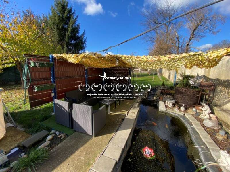 V exkluzívnom zastúpení majiteľa ponúkame na predaj rodinný dom - Záhrada rodinného domu na Hlavnej ulici v Zavare s vonkajším posedením a záhradným jazierkom.