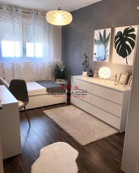 Exkl.4 iz novostavba RD - tepelné čerpadlo - Moravany nad Váhom - Izba v rodinnom dome s podlahou s dreveným dekorom, umeleckými obrazmi a dekoratívnymi kvetmi.