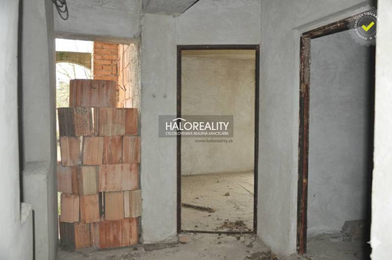 Predaj, rodinný dom Dolný Pial - VO VÝSTAVBE - Interiér rodinného domu s nedokončenou tehlovou stenou a surovými múrmi.