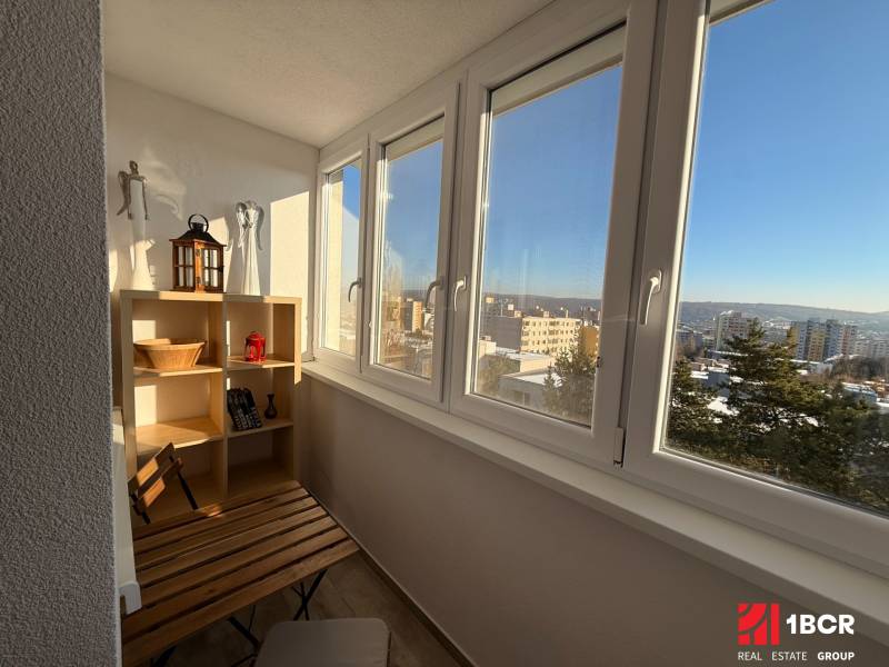 KRÁSNY, ÚTULNÝ A ŠTÝLOVÝ 3 IZBOVÝ BYT | DUBRAVKA - Lodžia v 3-izbovom byte s dreveným dekorom, výhľad na panorámu Bratislavy.