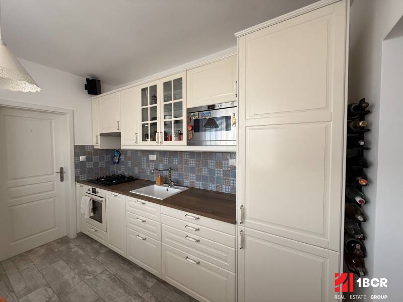 KRÁSNY, ÚTULNÝ A ŠTÝLOVÝ 3 IZBOVÝ BYT | DUBRAVKA - Kuchyňa v 3-izbovom byte s bielymi skrinkami a podlahou s dreveným dekorom.