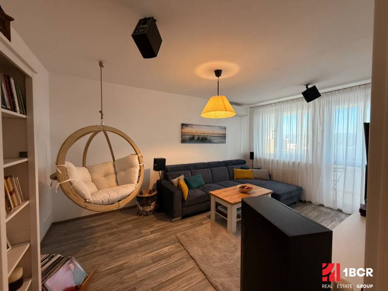 KRÁSNY, ÚTULNÝ A ŠTÝLOVÝ 3 IZBOVÝ BYT | DUBRAVKA - Obývačka s hojdačkou, rohovou sedačkou a podlahou s dreveným dekorom v 3-izbovom byte.