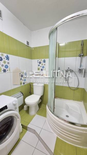 PRIESTRANNÝ 1-IZBOVÝ BYT, 38 M², BANSKÁ BYSTRICA - SITNIANSKA - Kúpeľňa v 1-izbovom byte so sprchovým kútom, práčkou a zeleno-bielymi kachličkami.