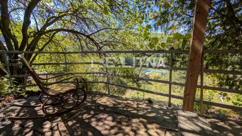 ZÁHRADA S UNIMOBUNKOU A VÝHĽADOM NA ZVOLEN , 465M2, ZVOLEN – HÁJIK - Hojdacie kreslo na terase s výhľadom na zeleň v Záhradách na Hájiku vo Zvolene.