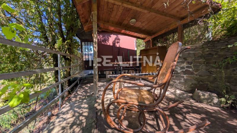 ZÁHRADA S UNIMOBUNKOU A VÝHĽADOM NA ZVOLEN , 465M2, ZVOLEN – HÁJIK - Záhrada na Hájiku vo Zvolene s dreveným prístreškom a hojdacím kreslom na terase.