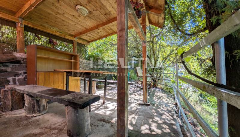 ZÁHRADA S UNIMOBUNKOU A VÝHĽADOM NA ZVOLEN , 465M2, ZVOLEN – HÁJIK - Prístrešok so stolom a lavičkou pod drevenou strechou v Záhradách na Hájiku vo Zvolene.