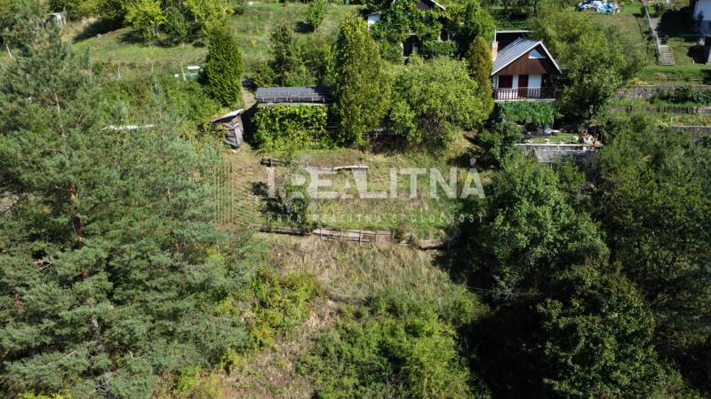 ZÁHRADA S UNIMOBUNKOU A VÝHĽADOM NA ZVOLEN , 465M2, ZVOLEN – HÁJIK - Záhrady v lokalite Hájik v meste Zvolen, obklopené hustou zelenou vegetáciou.