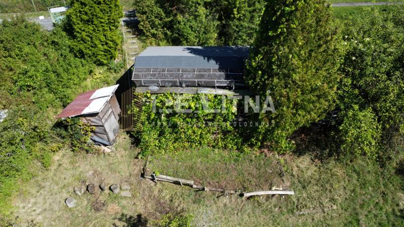 ZÁHRADA S UNIMOBUNKOU A VÝHĽADOM NA ZVOLEN , 465M2, ZVOLEN – HÁJIK - Záhrada na Hájiku vo Zvolene s drevenou búdovou a zarasteným pozemkom.