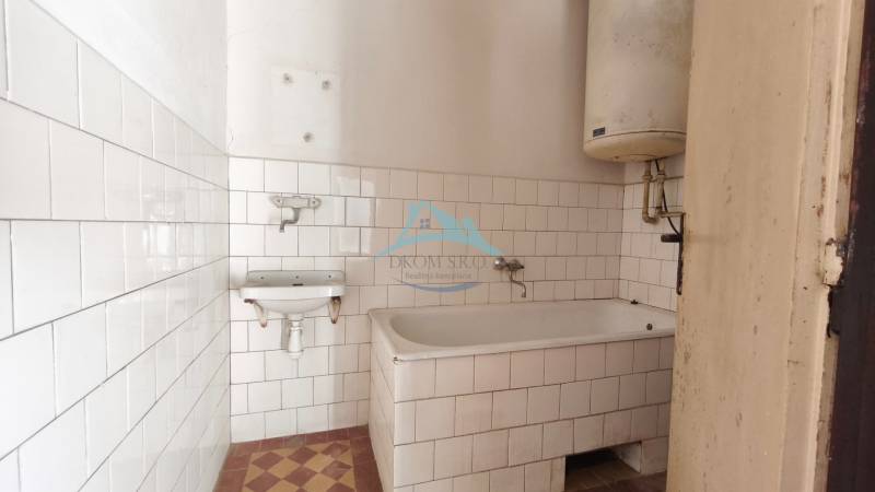 Rodinný dom v obci Čebovce v okrese Veľký Krtíš. - Kúpeľňa v rodinnom dome s vaňou, bielymi obkladačkami a ohrievačom vody.