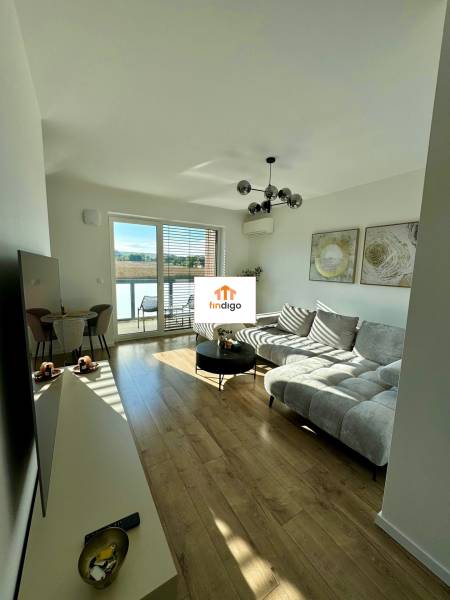 PREDAJ - 2-izbový byt v nádhernej lokalite Dvorníky - Obývačka v 2-izbovom byte s podlahou s dreveným dekorom a pohodlným sedením.