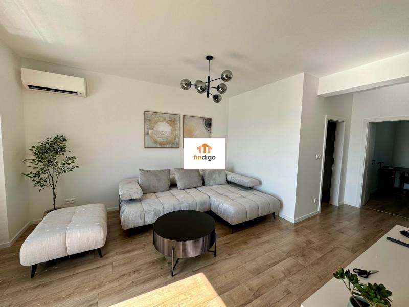 PREDAJ - 2-izbový byt v nádhernej lokalite Dvorníky - Obývacia izba v 2-izbovom byte s podlahou s dreveným dekorom a šedým nábytkom.