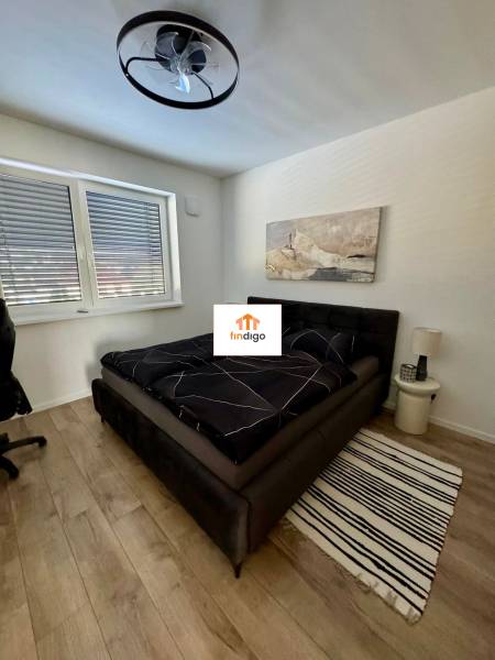 PREDAJ - 2-izbový byt v nádhernej lokalite Dvorníky - Spálňa v 2-izbovom byte so štýlovým lusterom a podlahou s dreveným dekorom.