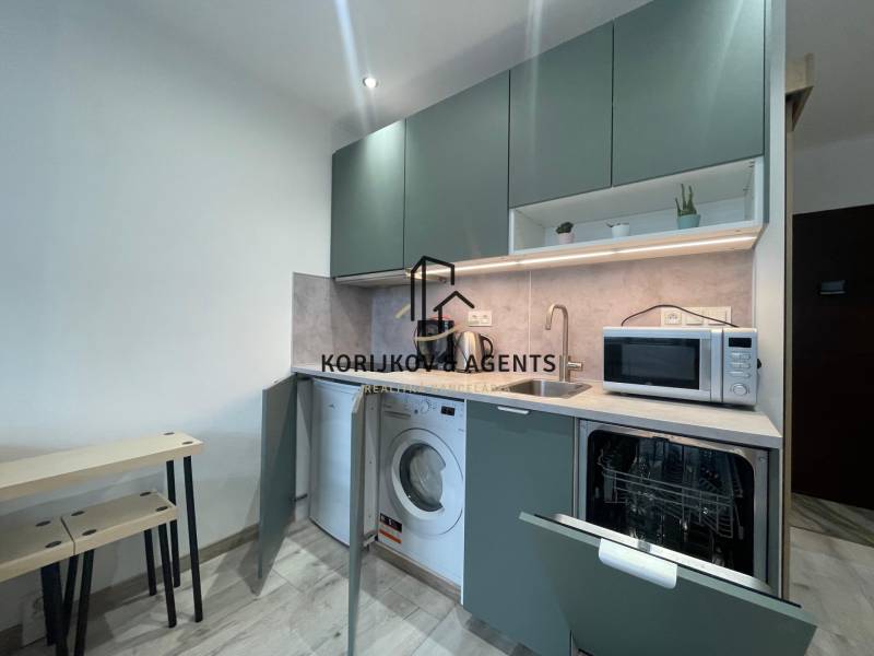 PRENÁJOM, garsónka na Jegorovovom námestí, Košice-Dargovských hrdinov - Kuchynský kút v garsónke s práčkou, mikrovlnkou a umývačkou, podlaha s dreveným dekorom.