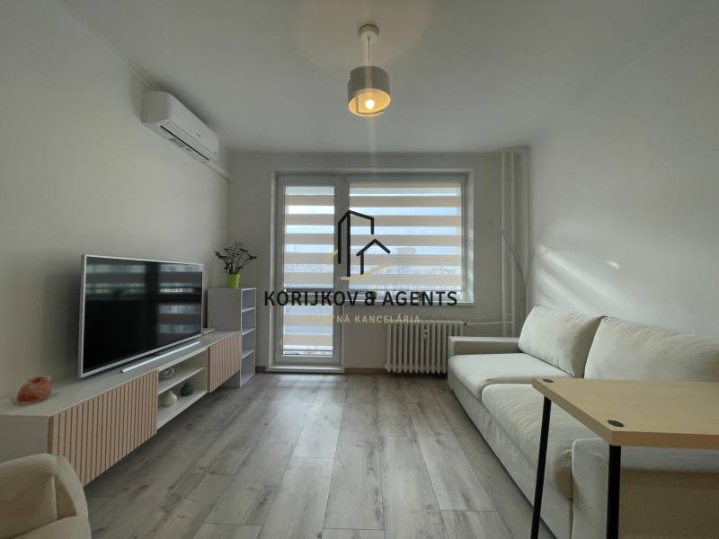 PRENÁJOM, garsónka na Jegorovovom námestí, Košice-Dargovských hrdinov - Garsónka so svetlým nábytkom, bielou sedačkou a podlahou s dreveným dekorom.