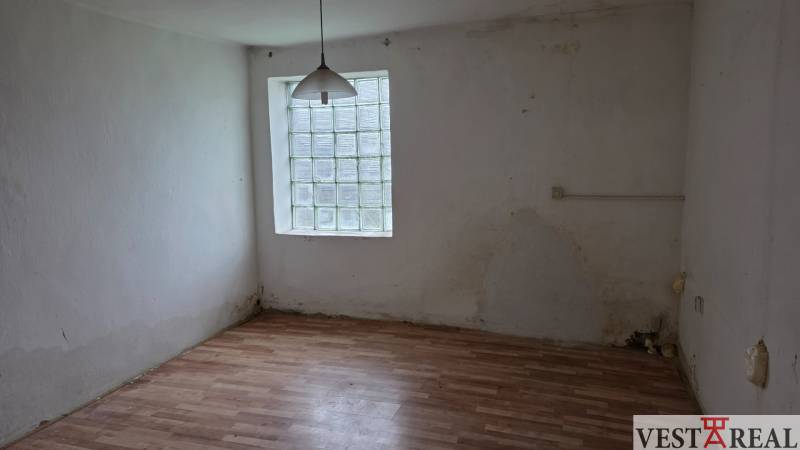 Na predaj 5 izbový rodinný dom Vinohrady nad Váhom - Miestnosť rodinného domu s podlahou s dreveným dekorom a oknom z luxferov.