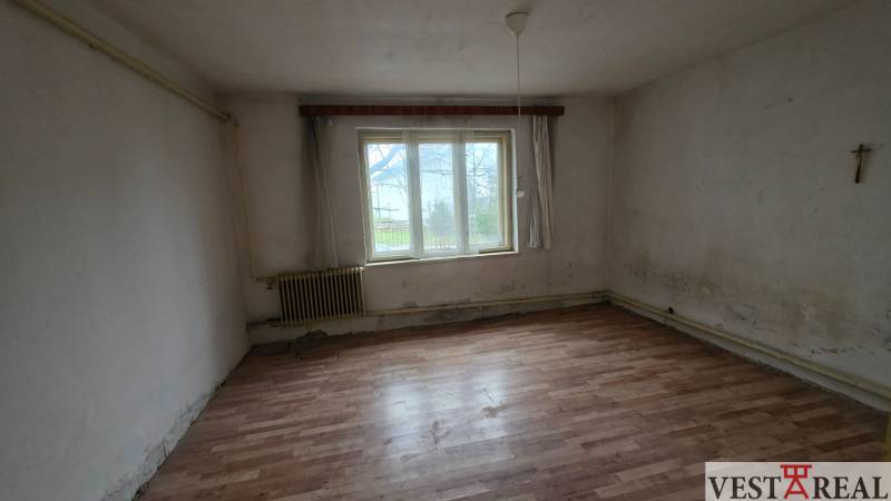 Na predaj 5 izbový rodinný dom Vinohrady nad Váhom - Izba s bielymi stenami a podlahou s dreveným dekorom v Rodinnom dome.