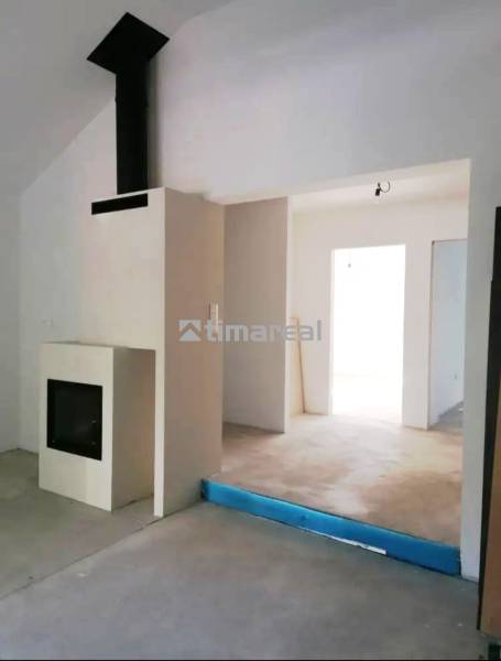 Novostavba- 3i dom s dvorom s nízkou údržbou - Interiér rodinného domu s kozubom, bielymi stenami a betónovými podlahami.