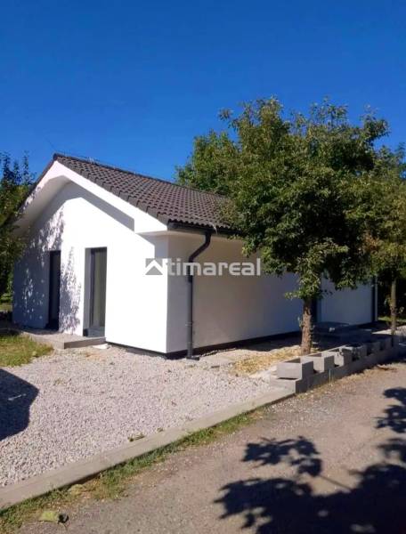 Novostavba- 3i dom s dvorom s nízkou údržbou - Rodinný dom v Kaplne s bielou fasádou, šikmou strechou a zeleňou okolo.