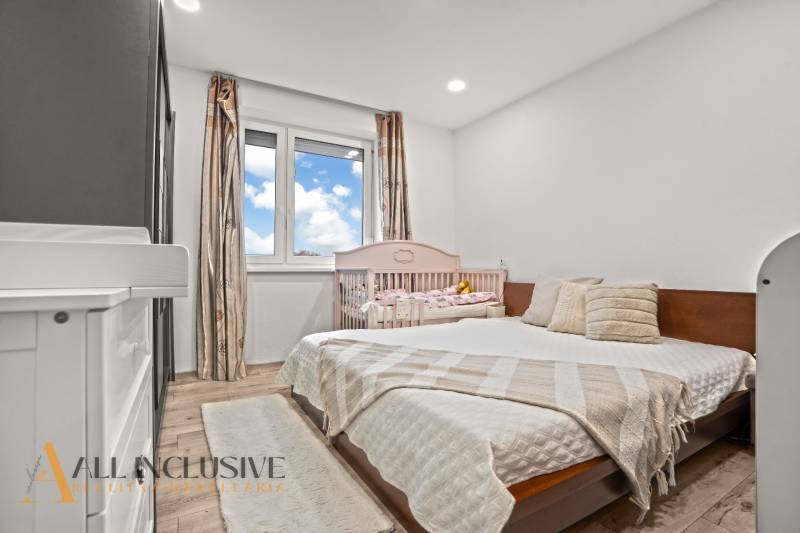 REZERVOVANÉ | NA PREDAJ 3-IZBOVÝ BYT S BALKÓNOM, VRAKÚŇ - Spálňa v 3-izbovom byte s podlahou s dreveným dekorom a detskou postieľkou.