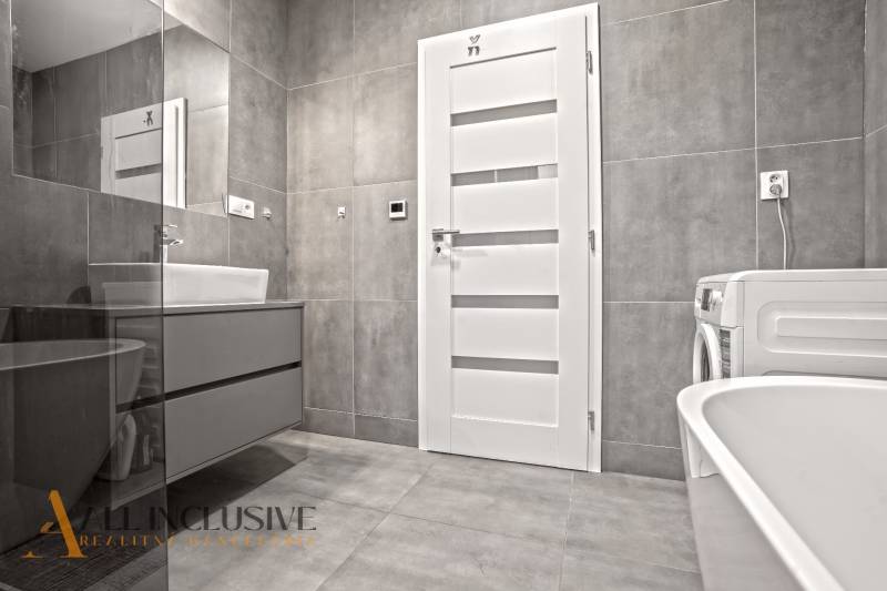 REZERVOVANÉ | NA PREDAJ 3-IZBOVÝ BYT S BALKÓNOM, VRAKÚŇ - Kúpeľňa v 3-izbovom byte s bielymi dverami, práčkou a umývadlom.