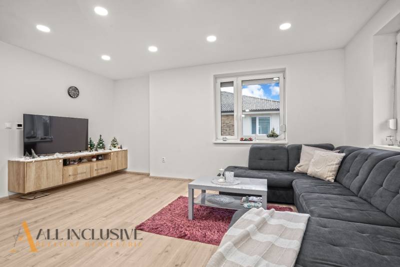 REZERVOVANÉ | NA PREDAJ 3-IZBOVÝ BYT S BALKÓNOM, VRAKÚŇ - Obývacia izba s rohovou sedačkou, podlahou s dreveným dekorom a televízorom v 3-izbovom byte.