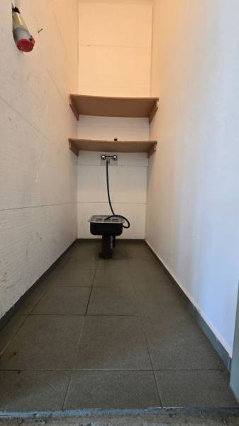 Prenájom haly v Šali – Veča | 220 m² | Ideálne na podnikanie - Úzke miestnosť s umývadlom, hadicou a policami v skladoch a halách.