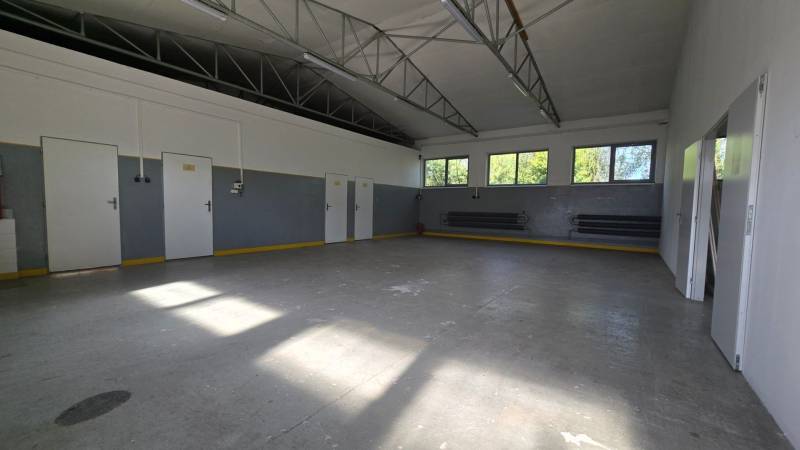 Prenájom haly v Šali – Veča | 220 m² | Ideálne na podnikanie - Priestor skladov a hál s veľkými oknami a betónovou podlahou.