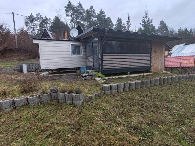 Pohoda pri vode, chata s výhľadom na Domašu - Chata v Novej Kelči na Hlavnej ulici, obklopená trávnikom a obrubníkmi.