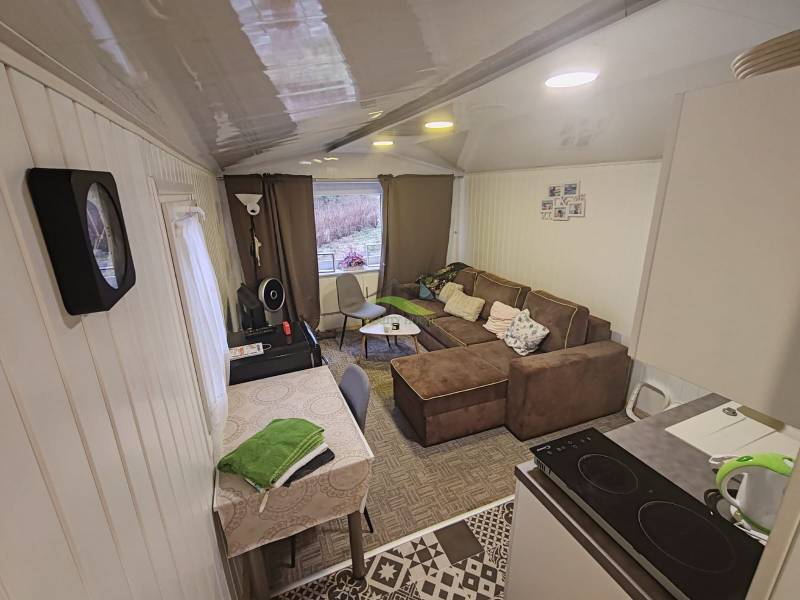 Pohoda pri vode, chata s výhľadom na Domašu - Interiér chaty s pohovkou, jedálenským stolom a vybavenou kuchyňou.