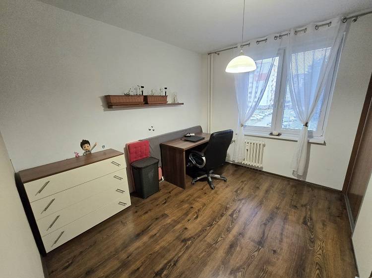 Predaj,trojizbový byt SNP, Holíč - Pracovňa v 3-izbovom byte s podlahou s dreveným dekorom, stolom a stoličkou.