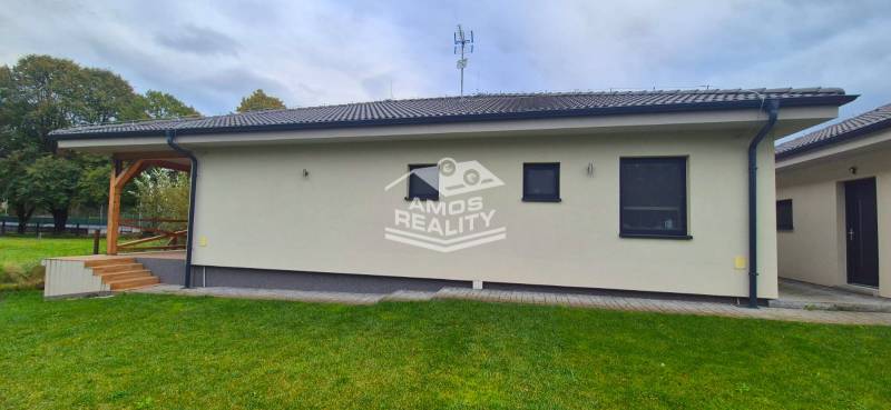 Na predaj 4 izbový RD v obci  Studienka, garáž, sauna, pozemok 719 m2 - Rodinný dom v Studienke s terasou, zeleným trávnikom a modernou fasádou.