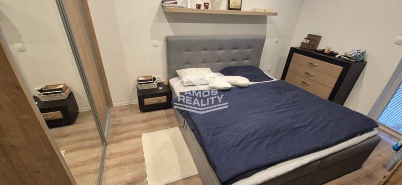 Na predaj 4 izbový RD v obci  Studienka, garáž, sauna, pozemok 719 m2 - Spálňa s podlahou s dreveným dekorom, posteľou a úložnými priestormi v rodinnom dome.