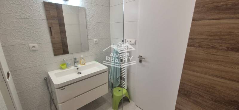 Na predaj 4 izbový RD v obci  Studienka, garáž, sauna, pozemok 719 m2 - Kúpeľňa v rodinnom dome s umývadlom, reliéfne dlaždice, zrkadlo a osvetlené steny.