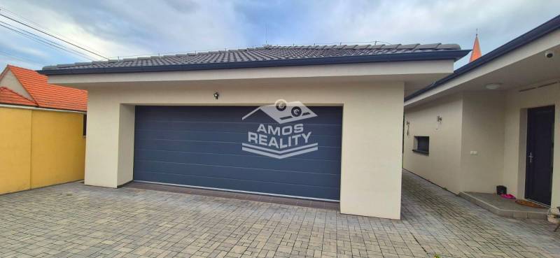 Na predaj 4 izbový RD v obci  Studienka, garáž, sauna, pozemok 719 m2 - Garáž s dlažbou pri rodinnom dome v Studienke, s kamennou dlažbou a sivou bránou.