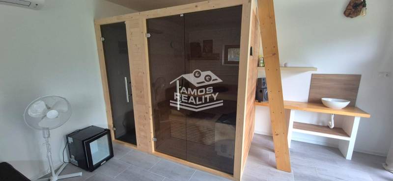 Na predaj 4 izbový RD v obci  Studienka, garáž, sauna, pozemok 719 m2 - Interiér rodinného domu so saunou, ventilátorom a umývadlom na drevenom stole.